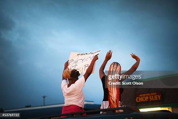 Demonstrators raise their arms during a protest against the killing of teenager Michael Brown on August 17, 2014 in Ferguson, Missouri. Despite the...