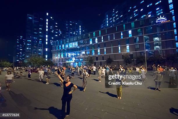 People dance at the plaza of Beijingxiangsu Community at night on August 18, 2014 in Beijing, China.