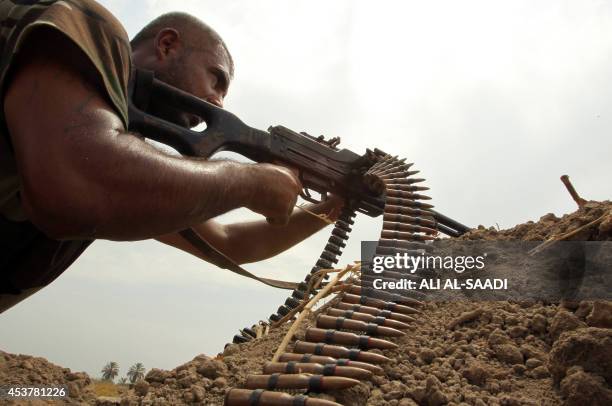 Shiite fighter loyal to Iraqi Shiite cleric Moqtada al-Sadr, holds a position as they back the Iraqi army in the fight against Islamic State...