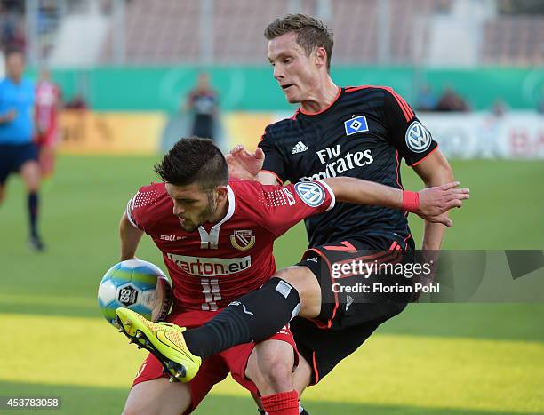 Fanol Perdedaj of FC Energie Cottbus competes with Marcell Jansen of Hamburger SV during the DFP Cup first round match between Energie Cottbus and...