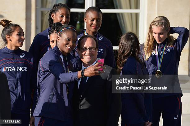 Women's 4 x 400m Relay gold medalist Muriel Hurtis takes a selfie with French President Francois Hollande at Elysee Palace on August 18, 2014 in...