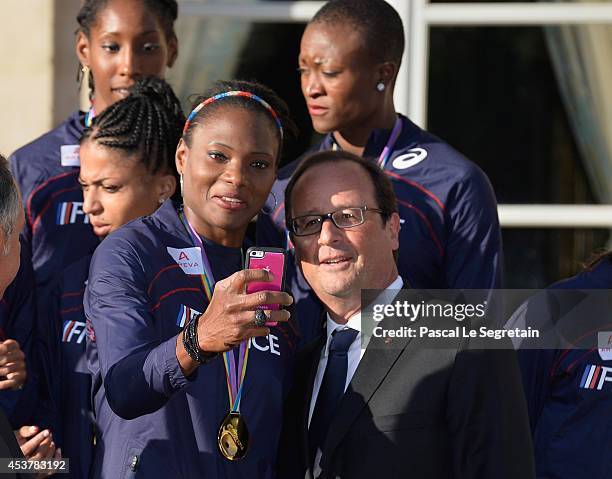 Women's 4 x 400m Relay gold medalist Muriel Hurtis takes a selfie with French President Francois Hollande at Elysee Palace on August 18, 2014 in...