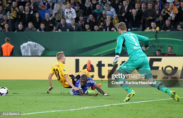 Luca Duerholtz of Dresden is fouled, winning a penalty kick, by Felipe Santana of Schalke 04 during the DFB Cup between SG Dynamo Dresden and FC...