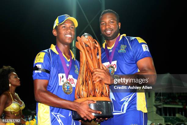 Kieron Pollard and Akeal Hosien of Barbados Tridents pose with the trophy after winning the Limacol Caribbean Premier League 2014 final match between...