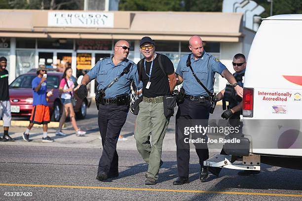 Getty Images staff photographer Scott Olson is placed into a paddy wagon after being arrested by police as he covers the demonstration following the...