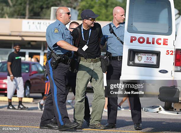 Getty Images staff photographer Scott Olson is placed into a paddy wagon after being arrested by police as he covers the demonstration following the...