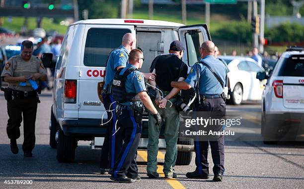 Getty Images staff photographer Scott Olson is placed into a paddy wagon after being arrested by police as the protests in the Missouri city of...