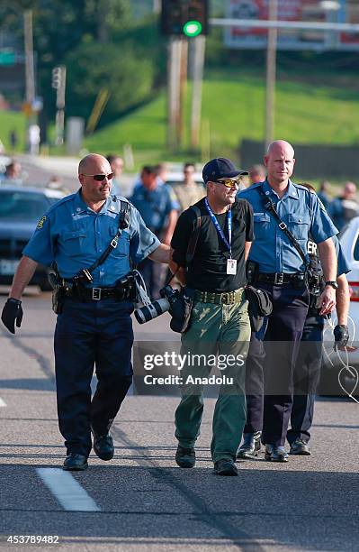Getty Images staff photographer Scott Olson walks to paddy wagon after being arrested by police as the protests in the Missouri city of Ferguson over...