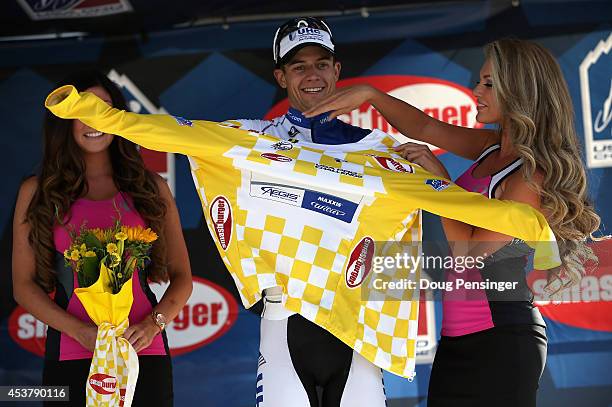 Kiel Reijnen of the United States riding for UnitedHealthcare Pro Cycling takes the podium to receive the overall race leader's yellow jersey after...