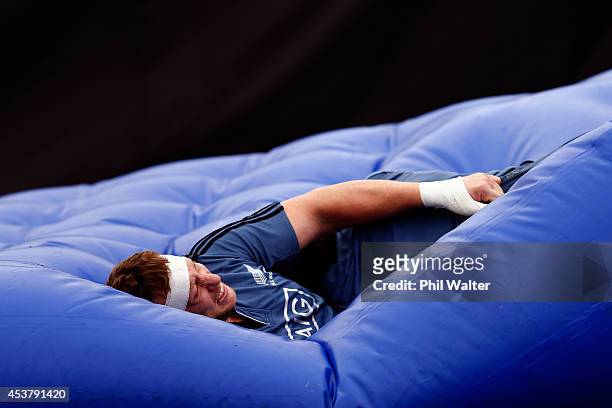 Wyatt Crockett of the All Blacks lands in the tackle matress during a New Zealand All Blacks training session at Trusts Stadium on August 19, 2014 in...