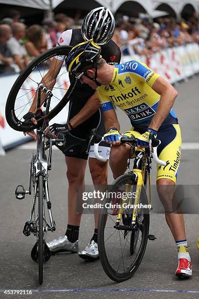 Jens Voigt of Germany riding for Trek Factory Racing shows off his bike to Michael Rogers of Australia riding for Tinkoff-Saxo during stage one of...