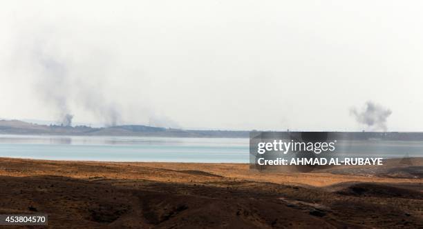 Smoke rises in the horizon following US airstrikes targeting Islamic State militants at Mosul Dam on the outskirts of the northern city of Mosul...