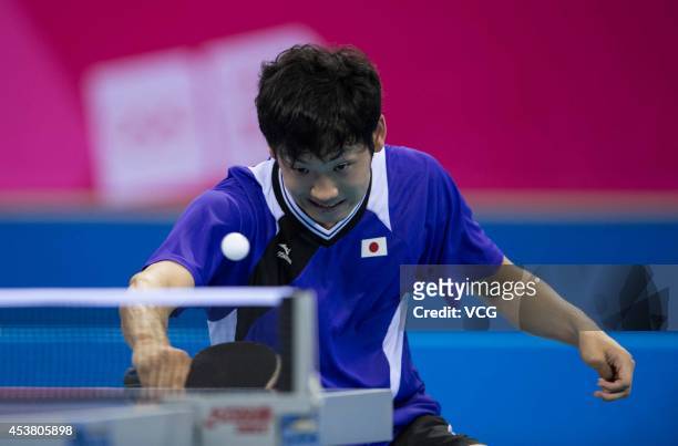 Yuto Muramatsu of Japan competes with Kim Minhyeok of South Korea in the Men's Singles Table Tennis quarter-final match on day three of the Nanjing...