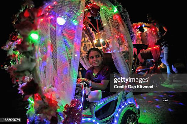 Young palestinian girl is pushed through a recreational park area on a colourful cart on August 14, 2014 in Gaza City, Gaza. A new five-day ceasefire...