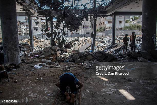 Palestinians pray at Friday noon prayers in the remains of Al-Susi Mosque on August 15, 2014 in Gaza City, Gaza. A new five-day ceasefire between...