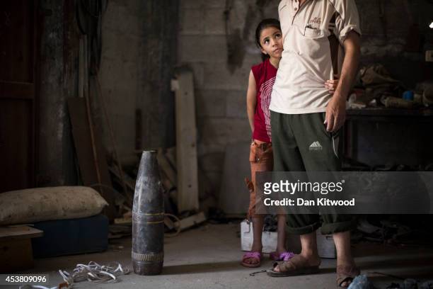 Saja Al Banna stands besides the remains of a missile that destoyed their home with her father on August 16, 2014 in Gaza City, Gaza. A five-day...