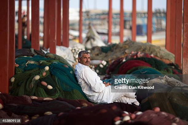 Palestinian man relaxes on fishing nets on August 15, 2014 in Gaza City, Gaza. Recent restrictions imposed by neighboring Israel, has meant that...