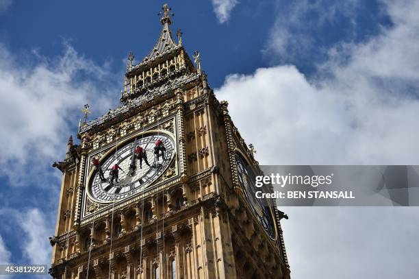 Technicians carry out cleaning and maintenance work on one of the faces of the Great Clock atop the landmark Elizabeth Tower that houses Big Ben,...