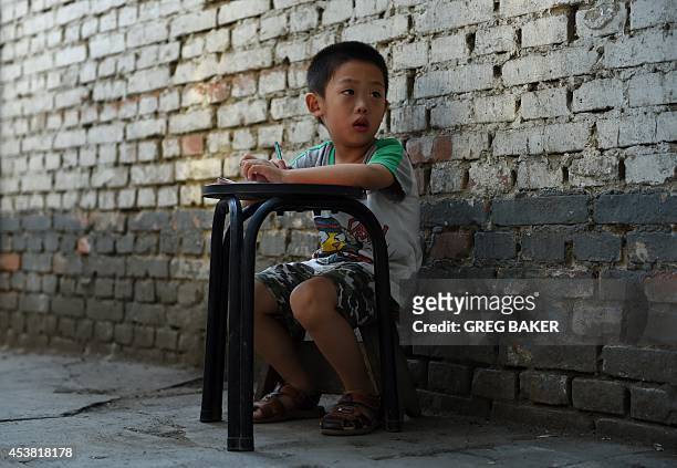 Four-year-old boy takes a break while practicing writing Chinese characters in Beijing on August 19, 2014. China's Ministry of Education has said...