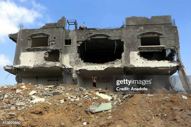 Palestinian children collect their usable staff inside the debris after attacks of Israeli forces in Gaza city, Gaza on 19 August, 2014.