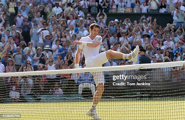 Andy Murray kicks a tennis ball as he celebrates just after winning the mens singles final beating Novak Djokovic on Centre Court during Wimbledon...