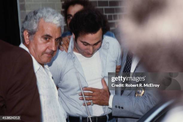 Police officers escort American accused serial killer David Berkowitz , known as the Son of Sam, into the 84th precinct station, New York, New York,...