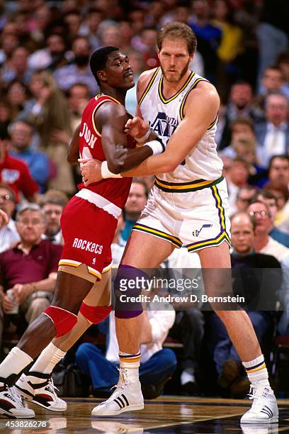 Mark Eaton of the Utah Jazz defends against Hakeem Olajuwon of the Houston Rockets circa 1990 at the Salt Palace in Salt Lake City, Utah. NOTE TO...