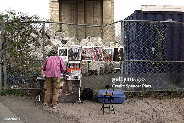 Man sells pictures at his stand in DUMBO, an acronym for Down Under the Manhattan Bridge Overpass, on August 19, 2014 in the Brooklyn borough of New...