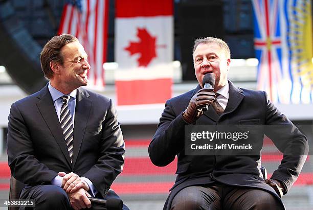 John Collins, NHL Chief Operating Officer listens as Mike Gillis, Vancouver Canucks President and General Manager, talks during a media availability...