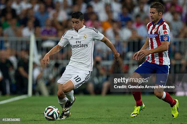 James Rodriguez of Real Madrid CF competes for the ball with Gabi Fernandez of Atletico de Madrid during the Supercopa first leg match between Real...
