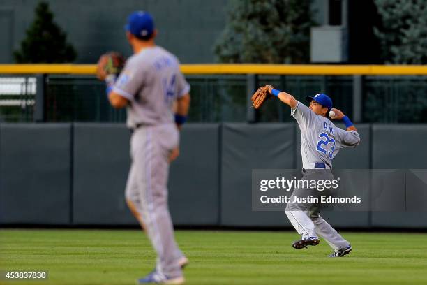 Right fielder Norichika Aoki of the Kansas City Royals throws to third base during the second inning as second baseman Omar Infante looks on against...