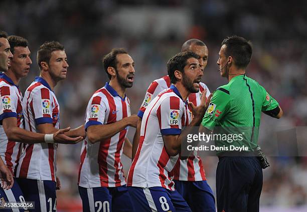Raul Garcia of Club Atletico de Madrid argues with referee Estrada Fernandez during the Supercopa first leg match between Real Madrid and Club...