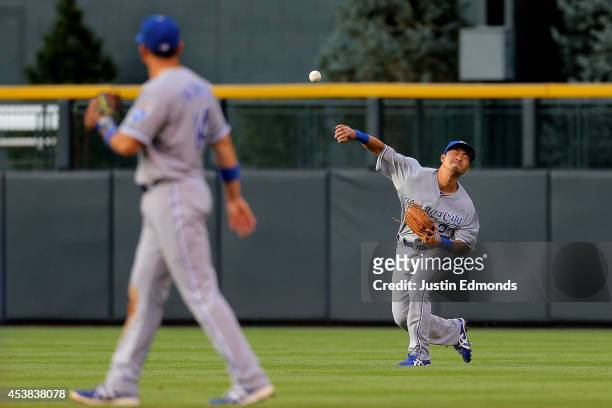 Right fielder Norichika Aoki of the Kansas City Royals throws to third base during the second inning as second baseman Omar Infante looks on against...