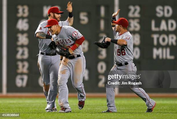 Josh Hamilton, Kole Calhoun, and Mike Trout of the Los Angeles Angels of Anaheim celebrate a 4-3 win against the Boston Red Sox at Fenway Park on...