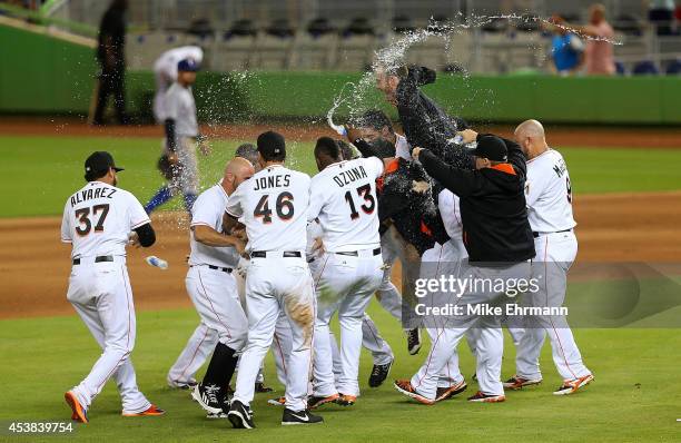 Giancarlo Stanton of the Miami Marlins is congratulated after hitting a walk off single to beat the Texas Rangers 4-3 at Marlins Park on August 19,...