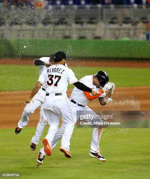 Giancarlo Stanton of the Miami Marlins is congratulated after hitting a walk off single to beat the Texas Rangers 4-3 at Marlins Park on August 19,...