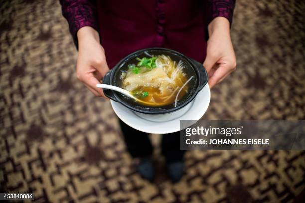 China-environment-social-food-economy,FOCUS by Felicia SONMEZ This photo taken on August 10, 2014 shows a waitress serving shark fin soup in a...