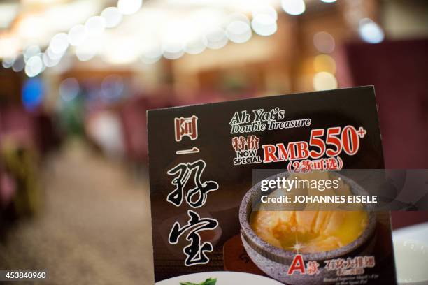 China-environment-social-food-economy,FOCUS by Felicia SONMEZ This photo taken on August 10, 2014 shows an advertisement for shark fin soup at a...