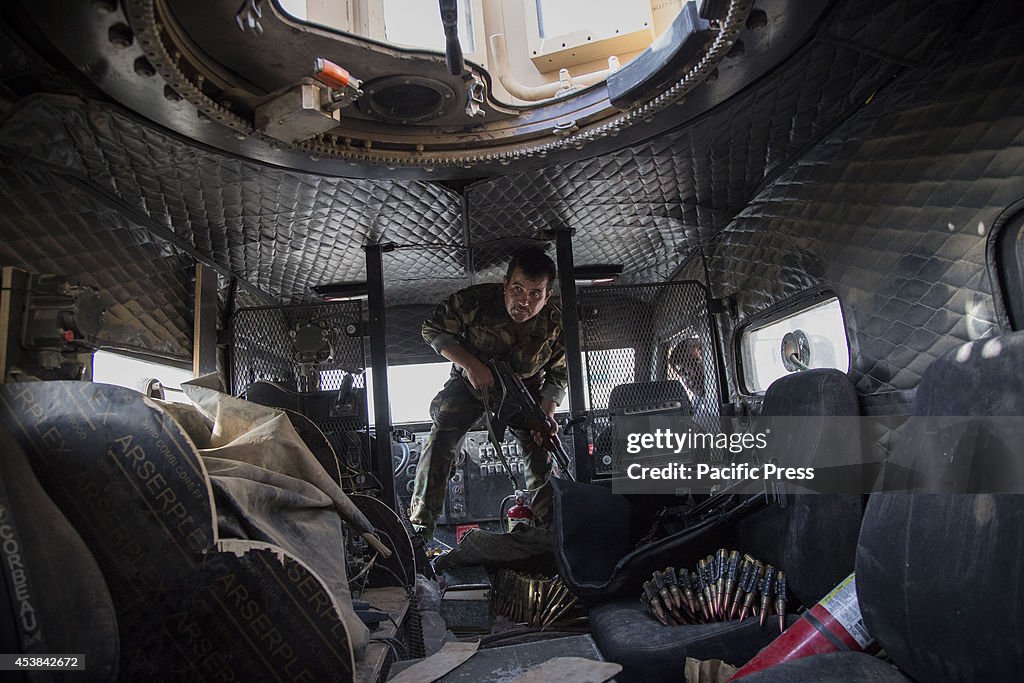 A Peshmerga fighter enters  an MRAP vehicle.  Makhmour is a...
