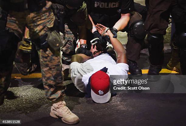 Police arrest a demonstrator protesting the killing of teenager Michael Brown on August 19, 2014 in Ferguson, Missouri. Brown was shot and killed by...