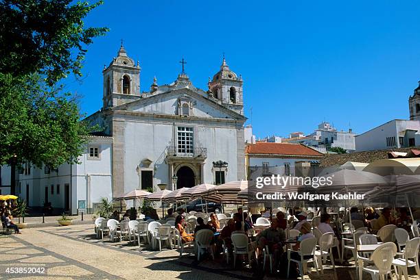 Portugal, Algarve, Lagos, Sidewalk Cafe With Church Of Santa Maria .