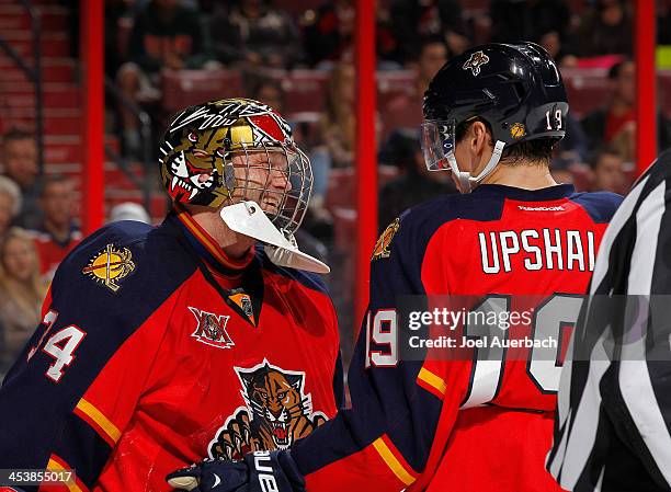 Goaltender Tim Thomas smiles as he talks to Scottie Upshall of the Florida Panthers after stopping a shot by Devin Setoguchi of the Winnipeg Jets...