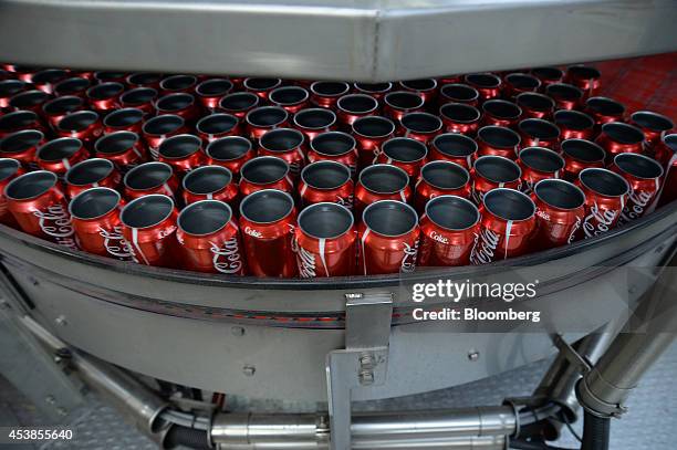 Empty Coca-Cola Classic cans move along a conveyor to be filled and sealed at a Coca-Cola Amatil Ltd. Production facility in Melbourne, Australia, on...