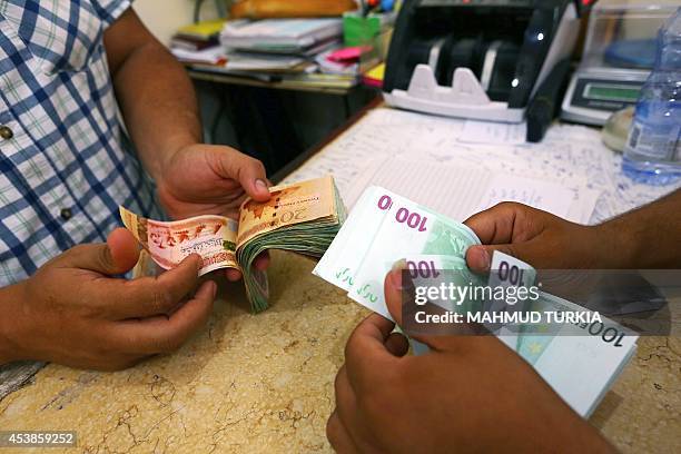 Currency is changed at a currency exchange in the Souk il-Jumaa district, in the center of the Libyan capital Tripoli, on August 20, 2014. Regular...