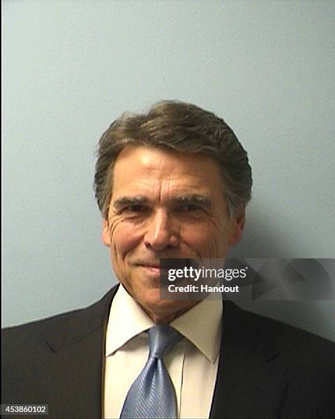 In this handout provided by the Travis County Sheriffs Office, Texas Gov. Rick Perry poses for a mug shot photo after turning himself in to...