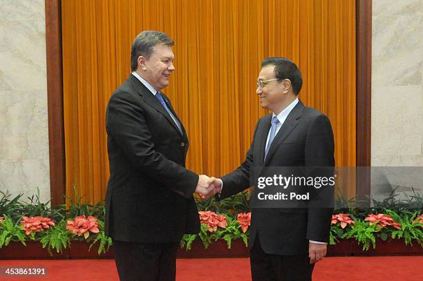 Ukrainian President Viktor Yanukovych shakes hands with Chinese Premier Li Keqiang at the Great Hall of the People in Beijing on December 6, 2013 in...