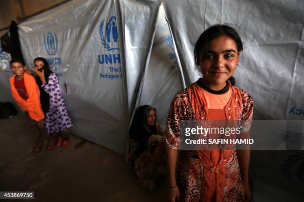 Young Iraqis, who fled violence in the northern city of Tal Afar, stand next to a tent at the Bahrka camp, 10 km west of Arbil in the autonomous...