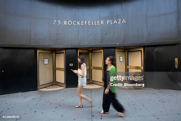 Pedestrians walk past 75 Rockefeller Plaza in New York, U.S., on Monday, Aug. 18, 2014. New landlord RXR Realty Corp. Is upgrading the entire 630,000...
