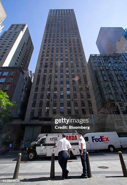 Security officers stand in front of 75 Rockefeller Plaza in New York, U.S., on Monday, Aug. 18, 2014. New landlord RXR Realty Corp. Is upgrading the...