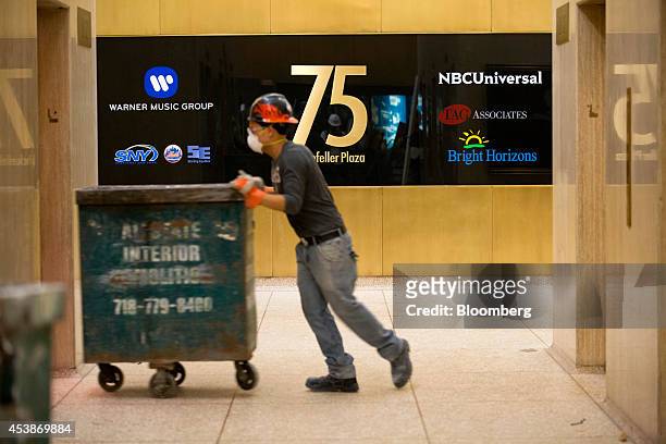 Worker pushes a crate for demolition work into an elevator in 75 Rockefeller Plaza during demolition ahead of renovations ahead of renovations in New...